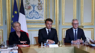 Frankrikes president Emmanuel Macron på söndagens krismöte med premiärminister Élisabeth Borne (till vänster) och ekonomiminister Bruno Le Maire (till höger).