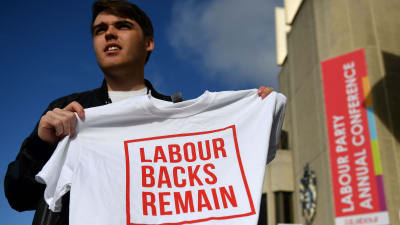 En aktivist håller upp en t-shirt med texten "Labour backs remain"