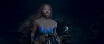 Sjöjungfrun Ariel i sin skattkammare på havets botten tittar upp mot ljuset från ytan.