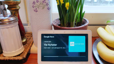 Smarthögtalare med skärm i ett kök. Högtalaren spelar upp Yle Nyheter.