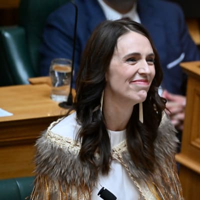Jacinda Ardern parlamentissa, yllään höyhenillä koristettu korowai-viitta