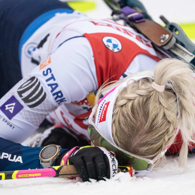 Erika Jänkä ligger med ansiktet mot snön.
