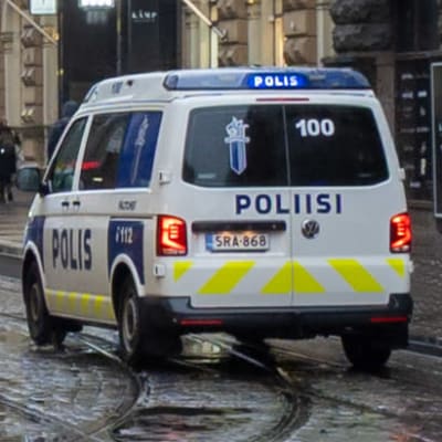 Polisbil kör bland människor på Alexandersgatan i Helsingfors. 
