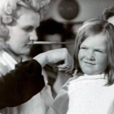 Nuoren tytön hiuksia leikataan jatkosodan aikana