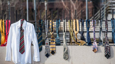 Kosovaner har hängt upp skjortor och slipsar på stängslet utanför regeringskansliet i Pristina.