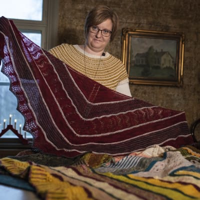kvinna håller upp stickad sjal