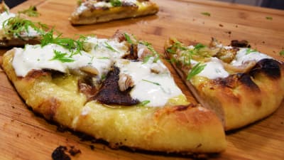 Hemgjord pizza på skärbräde.