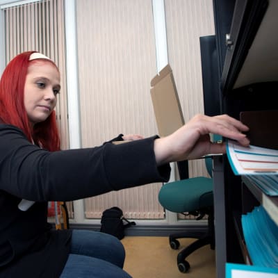 Laura ottaa hyllystä materiaaleja.