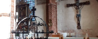 insidan i pargas kyrka - syns jesus på korset och ljusställning i metall