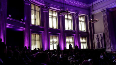 Helsingfors universitets festsal i lila belysning.