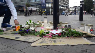 Blommor och ljus placeras vid platsen där offret misshandlades.
