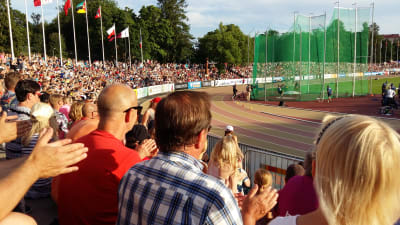Fullt med publik följer med friidrottstävlingar i sommarvärmen på Paavo Nurmi stadion i Åbo. Släggkastning på gång.