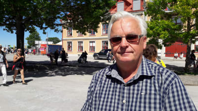 Tommy Gardell, i solglasögon och rutig skjorta, på solig gata i Visby.