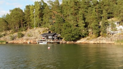 Sommarstuga med bastu och båt vid strandlinjen på Luonnonmaa i Nådendal.