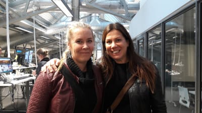 Två skådespelare, Jonna Nyman och Marika Parkkomäki står bredvid varandra och poserar i Logomo i Åbo.