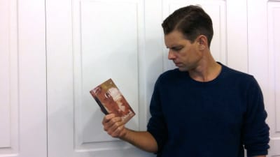Alex Schulman håller i boken "Glöm mig".