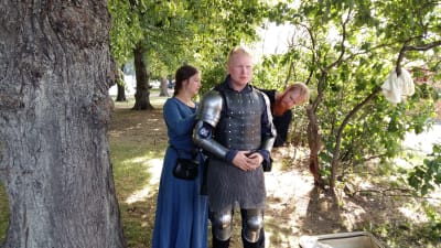 Gunnar Cederberg, alias Franska liljan, får hjälp av sin jungfru och sin väpnare med att klä på sig rustningen.