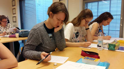 Jasmine Öjbro och tre andra utländska kvinnor läser finska på en kurs.