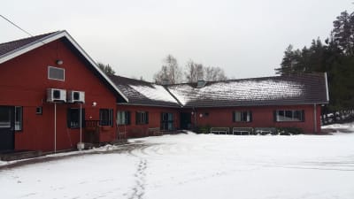 Röda låga lägerskolbyggnader.