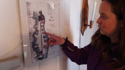 Camilla Juthbacka tittar på gammal karta över Djupsten i Nykarleby