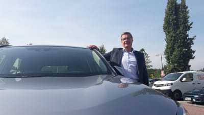 Vd Pekka Rissa vid Bilhandelns centralförbund poserar vid en bil. 