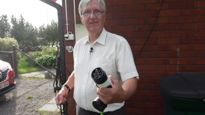 Thomas Lindroos i Sibbo visar upp sin elbilsladdare