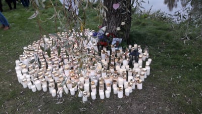 Ljus till åminnelse av en död flykting från Afghanistan vid Nykarleby älv.