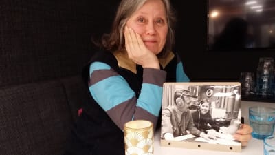 Kvinna håller upp svartvitt fotografi 