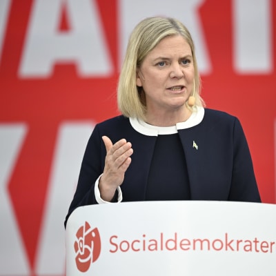 Magdalena Andersson i talarstolen, som det står Socialdemokraterna på.