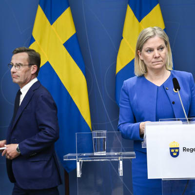 Ulf Kristersson ja Magdalena Andersson taustallaan Ruotsi lippuja.