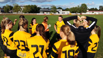 Hibo Mohamed, Janina Orell och Malin Selén med sina lagkamrater i ÅIFK:s damlag i fotboll.