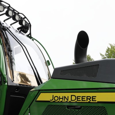 Närbild av en grön och gul John Deere skogstraktor.