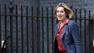 Amber Rudd i röd mönstrad tröja och blå kostym på väg till 10 Downing Street för att utnämnas till inrikesminister av Theresa May.