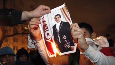 Demonstranter i Paris bränner en bild på president Zine al Abidine Ben Ali.