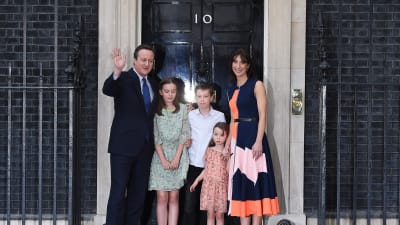 David Cameron tillsammans med sina tre barn och frun Samantha utanför premiärministerns bostad 10 Downing Street med en svart dörr med siffran 10 på.