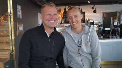 Jonte Wingren i en svart tröja och Sara Åström i en grå tröja. De sitter på ett café, i bakgrunden syns caféets kassa.