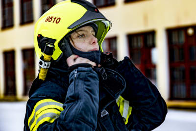 kvinna i brandmanskläder 