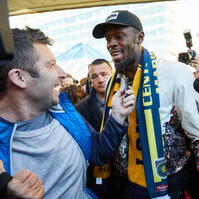 Usain Bolt omringas av journalister i Sydney.
