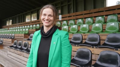 Raseborgs stadsdirektör Petra Theman står vid läktaren på en fotbollsplan.