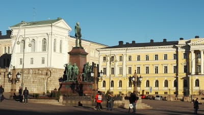 Turister som tittar på statyn av Alexander II på senatstorget