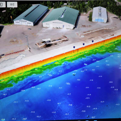 Tietokoneen näytöllä 3D-mallinnettu Hallan satama halleineen ja satama-altaineen.