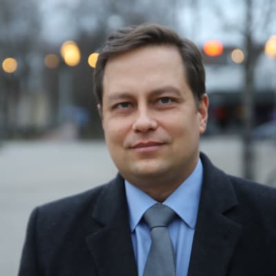 Mies katsoo kameraan