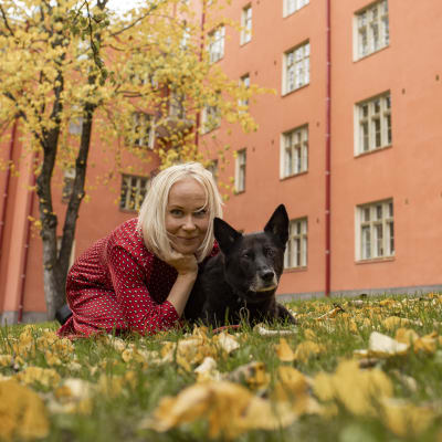 Filosofi Elise Aaltola nurmikolla koiran kanssa.