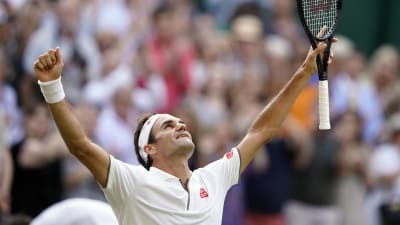 Roger Federer lyfter händerna upp mot skyn.