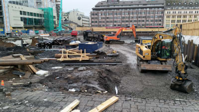 En del av ett staket har ramlat ner i gropen där parkeringen under Åbo salutorg byggs.