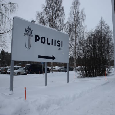 En stor skylt med polisens logo och texten "Oulu" (Uleåborg) och och en pil till höger.