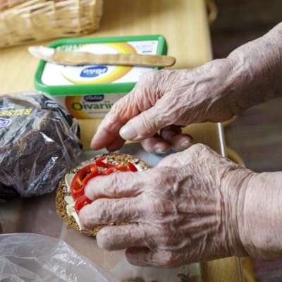 Vanhan naisen kädet tekemässä leipiä.