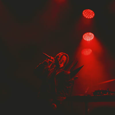 Tommy Cash esiintymässä Kesärauha-festivaaleilla Turussa. Koko lava on valaistu punaisella valolla. 