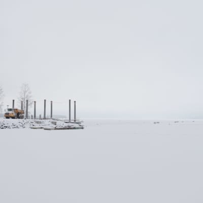 Tampereelle rakennettavan tekosaaren ponttooneja ja työkoneita talvella.