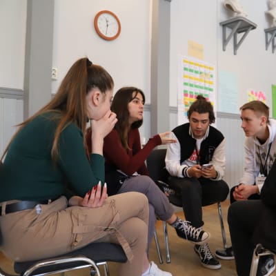 En grupp ungdomar på Erasmus+ utbyte diskuterar tilsammans.